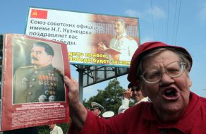 Еlderly woman holds the portrait of Stalin