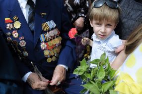 The boy stands near a veteran Great Patriotic war