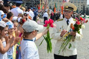 Мальчик дарит цветы ветерану