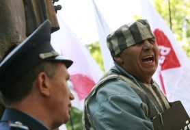 Милиционер возле мужчины в тюремной робе