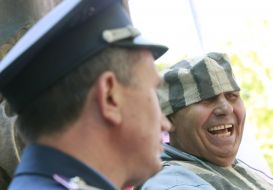 Милиционер возле мужчины в тюремной робе