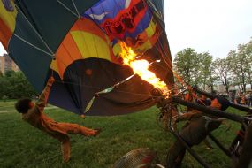 The participant of festival inflates a thermal balloon