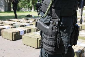 Боєць "Альфа" стоїть біля ящиків з кокаїном 