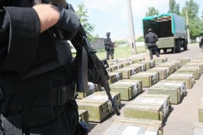 Боєць "Альфа" стоїть біля ящиків з кокаїном 