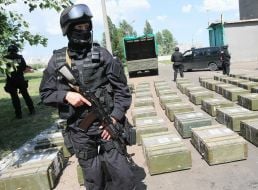 Боєць "Альфа" стоїть біля ящиків з кокаїном 