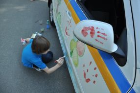 Boy draws on a car