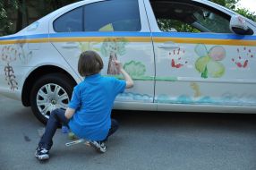 Boy draws on a car