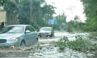 Cars drive on flooded street