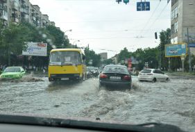 Cars drive on flooded street