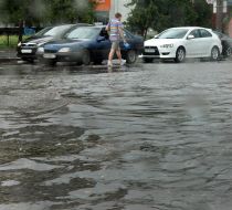 Cars drive on flooded street