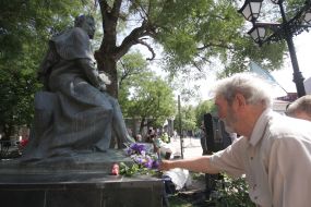 Man lays flowers to the monument