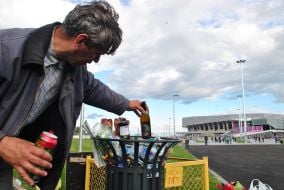 A man takes away bottles from trash