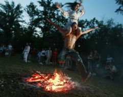 Young people jump through a fire 