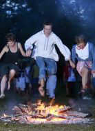Young people jump through a fire 