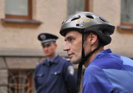 Сотрудник милиции стоит возле велосипедиста