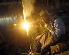 Сварщик варит вал турбины