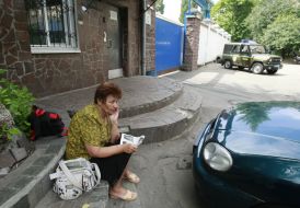 A woman sits near Lukyanovka pre-trial prison