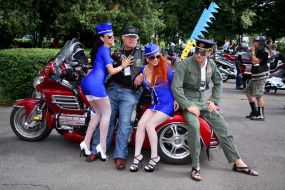 The girls in the form of flight attendants with bikers on motorcycle