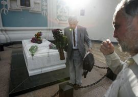 Чоловік покладає квіти до могили