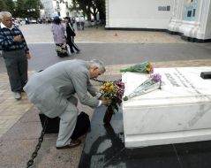 Чоловік покладає квіти до могили