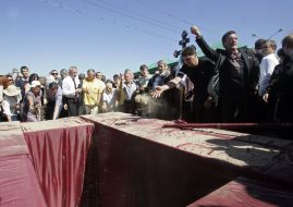 Люди кидають землю в могилу