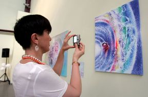 A woman photographs the picture