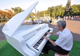 Музыкант играет на белом рояле