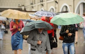 Passers with umbrellas