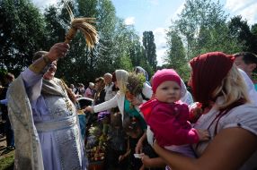 Священнослужитель освящает корзинки с яблоками