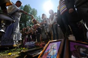 Священнослужитель освящает корзинки с яблоками