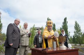 A priest sanctifies a capsule with earth from Pripyat