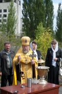 A priest sanctifies a capsule with earth from Pripyat