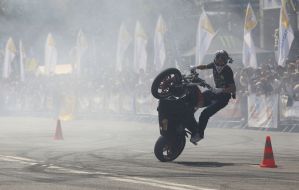 Young man executes a trick on the motor cycle 