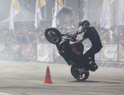 Young man executes a trick on the motor cycle 
