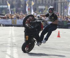 Young man executes a trick on the motor cycle 