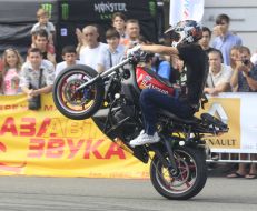 Young man executes a trick on the motor cycle 