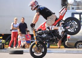 Участник байк-феста выполняет трюки