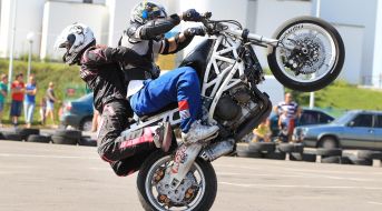 Участник байк-феста выполняет трюки