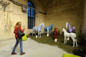 Посетительница возле скульптур лошадей