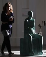 Посетительница возле скульптуры в виде беременной женщины