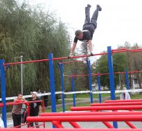 Young man  executes exercises on horizontal bar