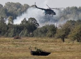 Helicopter MI-8 and BTR during military exercises