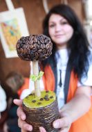 Visitor of festival keeps tree with coffee beans