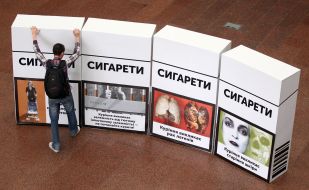 Protestor sets a pack of cigarettes
