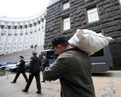 Участник акции несет мешок картошки