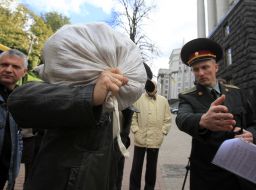 Участник акции несет мешок картошки