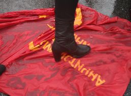 Участница митинга стоит на флаге с коммунистической символикой