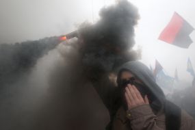 Участник Марша борьбы с дымовой шашкой