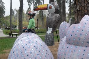 Ребенок сидит на скульптурной композиции