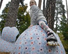 Девочка сидит на скульптурной композиции